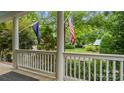 Inviting porch view featuring a manicured lawn and landscaping with an American flag at 6129 Caseys Side Way, Fort Mill, SC 29708