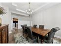 Elegant dining room with a wooden table, a chandelier, and views of the laundry area at 6261 Six String Ct, Fort Mill, SC 29708