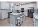 Modern kitchen showcasing a marble island with seating, stainless steel appliances, and ample cabinet space at 6914 Evanton Loch Rd, Charlotte, NC 28278