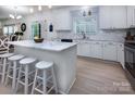 Open kitchen featuring an island with seating, white cabinets, and stainless steel appliances at 6914 Evanton Loch Rd, Charlotte, NC 28278