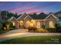 Beautiful exterior elevation of a brick and stone home with professional landscaping and warm lighting at 7412 Sahalee Dr, Denver, NC 28037