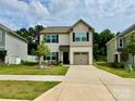 Charming two-story home with black shutters, a well-maintained lawn, and a beautiful front yard tree at 750 Fraternity Row, Kannapolis, NC 28081