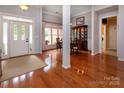 Bright foyer with hardwood floors, leading to a dining area with large windows and natural light at 8008 Alba Ct, Charlotte, NC 28269