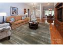Cozy living room with hardwood floors, comfortable seating, and an open view into the dining area at 8008 Alba Ct, Charlotte, NC 28269