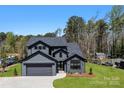 New construction home with gray siding, black trim, two car garage and professionally landscaped yard at 8039 Mcconnell Rd, Denver, NC 28037
