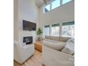 Bright living room featuring high ceilings, large windows, fireplace, and stylish modern furniture at 8039 Mcconnell Rd, Denver, NC 28037