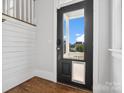Entryway featuring hardwood floors, white shiplap walls, and a modern black front door with glass at 807 Herrons Ferry Rd, Rock Hill, SC 29730