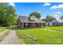 Traditional brick home with a lush, green lawn and a quaint, tree-lined neighborhood setting at 85 Ruritan Park Rd, Stony Point, NC 28678