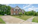 Beautiful two-story home with a long driveway, lush green lawn and mature trees at 9032 Cornflower Dr, Harrisburg, NC 28075