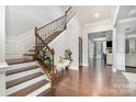 Grand foyer featuring a hardwood floor, staircase with decorative railing, and elegant lighting at 9032 Cornflower Dr, Harrisburg, NC 28075