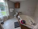 Bright bathroom featuring a tiled tub and a large window with natural light at 936 New Camp Creek Church Rd # 11, Kings Mountain, NC 28086
