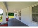 Inviting covered front porch with classic support columns, a view of the yard, and paneled ceiling at 1070 Nc 182 Hwy, Lincolnton, NC 28092
