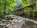 Relaxing backyard featuring a water feature, stone pathway, and views of the tree-lined property at 10710 Bristlecone Ct, Mint Hill, NC 28227