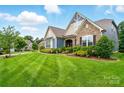 Inviting home featuring a manicured lawn, a mix of stone and siding, and mature landscaping at 10903 Skymont Dr, Huntersville, NC 28078