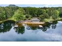 Picturesque lake view featuring a covered pier, a small sandy beach and a lakeside recreation building at 1102 Lake Montonia Rd, Kings Mountain, NC 28086