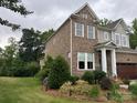 Well-maintained two-story home with brick siding, lush landscaping, and a green lawn at 1124 Greenbridge Dr, Matthews, NC 28105