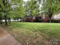 Lush green lawn and mature trees adorn this townhome community at 129 Steinbeck Way, Mooresville, NC 28117