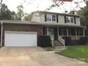 Charming two-story home with a brick facade, attached garage, and well-maintained front yard at 134 Crystal Cir, Mooresville, NC 28117