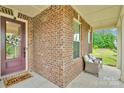 Inviting covered front porch with brick detailing, cozy seating, and a welcoming entrance at 1355 Cilantro Ct, Fort Mill, SC 29708
