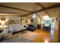 Inviting living room features exposed beams, hardwood floors, and a comfortable seating arrangement, perfect for gatherings at 1789 Paris Dr, Conover, NC 28613