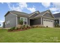 Well-maintained home featuring manicured lawn, mulch beds, and neutral siding at 1818 Winding Mist Dr, Belmont, NC 28012