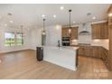 Modern kitchen boasts stainless steel appliances, wooden cabinets and a central island at 1818 Winding Mist Dr, Belmont, NC 28012