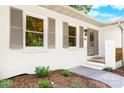 Close-up of the house entrance with decorative shutters and a well-maintained landscape at 201 Forest Rd, Taylorsville, NC 28681