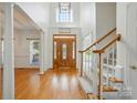 Bright foyer with hardwood floors, staircase, and large windows, creating an elegant entrance at 201 Limerick Dr, Matthews, NC 28104