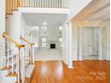 Open living room with fireplace, staircase, and large windows, offering a bright and airy space at 201 Limerick Dr, Matthews, NC 28104