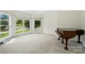 Bright sitting room with large windows and a piano, creating a warm and inviting space at 201 Limerick Dr, Matthews, NC 28104