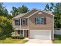 Charming two-story home with a two-car garage, red shutters, and a well-manicured lawn under a clear blue sky at 2021 Tarzi Ln, Charlotte, NC 28215