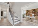Inviting foyer with a staircase, view of living room, and office entrance with built-in shelving at 203 Balboa St, Matthews, NC 28104