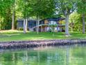 Lakefront home with a well-manicured lawn and multiple decks overlooking the water at 3248 Lake Shore S Rd, Denver, NC 28037