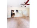 Empty living room featuring neutral walls, carpet flooring, a ceiling fan, and easy access to the kitchen at 3430 Fincher Blvd, Charlotte, NC 28269
