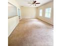 Empty living room featuring neutral walls, carpet flooring, and two windows for lots of natural light at 3430 Fincher Blvd, Charlotte, NC 28269