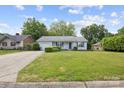 Inviting one-story home with lush lawn, a driveway, and charming curb appeal at 3721 Conway Ave, Charlotte, NC 28209