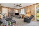 Cozy living room featuring carpet, wood paneling, fireplace, and a ceiling fan at 4059 10Th Avenue Sw Dr, Hickory, NC 28602