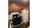 View of a kitchen with an electric oven, wood cabinets and a refrigerator at 415 N Secrest Ave, Monroe, NC 28110