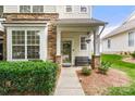 Inviting front porch with stone accents, bench seating, and well manicured bushes at 424 River Park Rd, Belmont, NC 28012