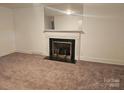 Spacious living room featuring a fireplace, mirror and carpet at 4520 Bradbury Dr, Charlotte, NC 28209