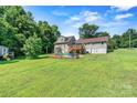 Expansive backyard with a playset, deck, and plenty of green space for outdoor activities and relaxation at 454 N Eastway Dr, Troutman, NC 28166