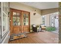 Inviting front porch featuring a double door entrance, stylish seating, and charming outdoor decor at 454 N Eastway Dr, Troutman, NC 28166