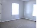 Bright, empty living room with two windows and neutral walls at 606 E 4Th Ave, Gastonia, NC 28054