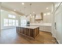 Bright kitchen featuring custom cabinets, a large island, pendant lighting and modern appliances at 608 Deodar Cedar Dr # 69, Matthews, NC 28104