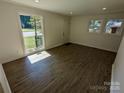 Bright living room featuring hardwood floors, large windows, and neutral paint at 631 Chipley Ave, Charlotte, NC 28205