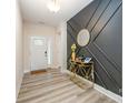 Elegant entryway with a decorative black accent wall, wood flooring and a modern gold console table at 705 Hinterland Ln, Matthews, NC 28104