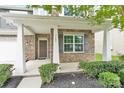 Charming covered front porch with stone pillars, decorative window shutters, and a neatly landscaped garden at 7101 Agnew Dr, Charlotte, NC 28273