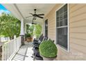 Relaxing covered front porch featuring rocking chairs, ceiling fans, and ample space at 7480 Katelyn Ct, Harrisburg, NC 28075