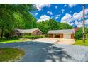 Beautiful brick home and detached garage with ample parking and an American flag at 7712 Old Waxhaw Monroe Rd, Waxhaw, NC 28173