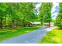 Charming brick home with long driveway, lush lawn, and detached two-car garage at 7712 Old Waxhaw Monroe Rd, Waxhaw, NC 28173